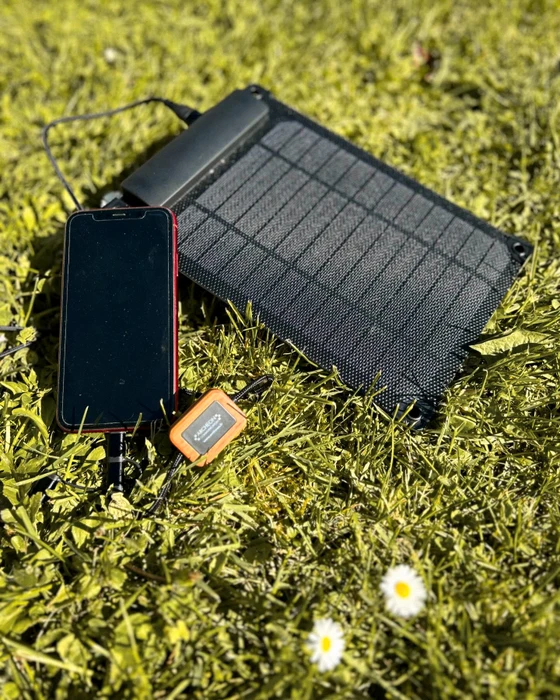 Photographie professionnelle en plan détaillé montrant une composition artistique de produits personnalisés Archéon arrangés de manière mise en scène : un t-shirt blanc ou clair avec broderie détaillée et colorée visible en gros plan, une tasse blanche avec décor imprimé en transfert DTF présentant un motif éclatant, et un accessoire promotionnel tel qu'une serviette ou un doudou de la marque Sardine Lotoise. Les articles sont disposés sur une surface en bois clair ou fond blanc cassé, photographiés sous lumière professionnelle mettant en valeur les textures, les finitions précises et les détails des personnalisations. L'image doit clairement montrer la qualité professionnelle des techniques de broderie et de transfert DTF, avec un rendu net et des couleurs éclatantes.